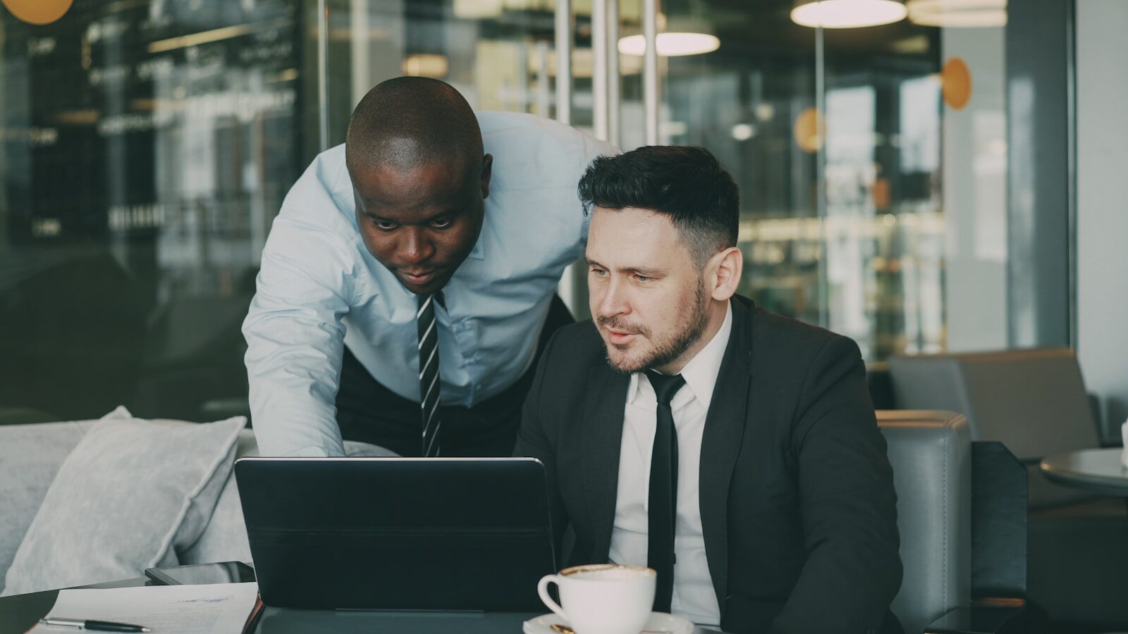 Two businessmen collaborating on a laptop